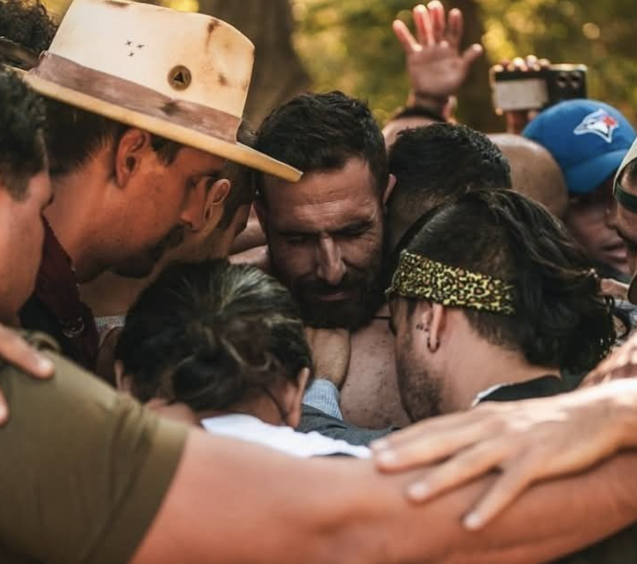 Men's community retreat, group embrace